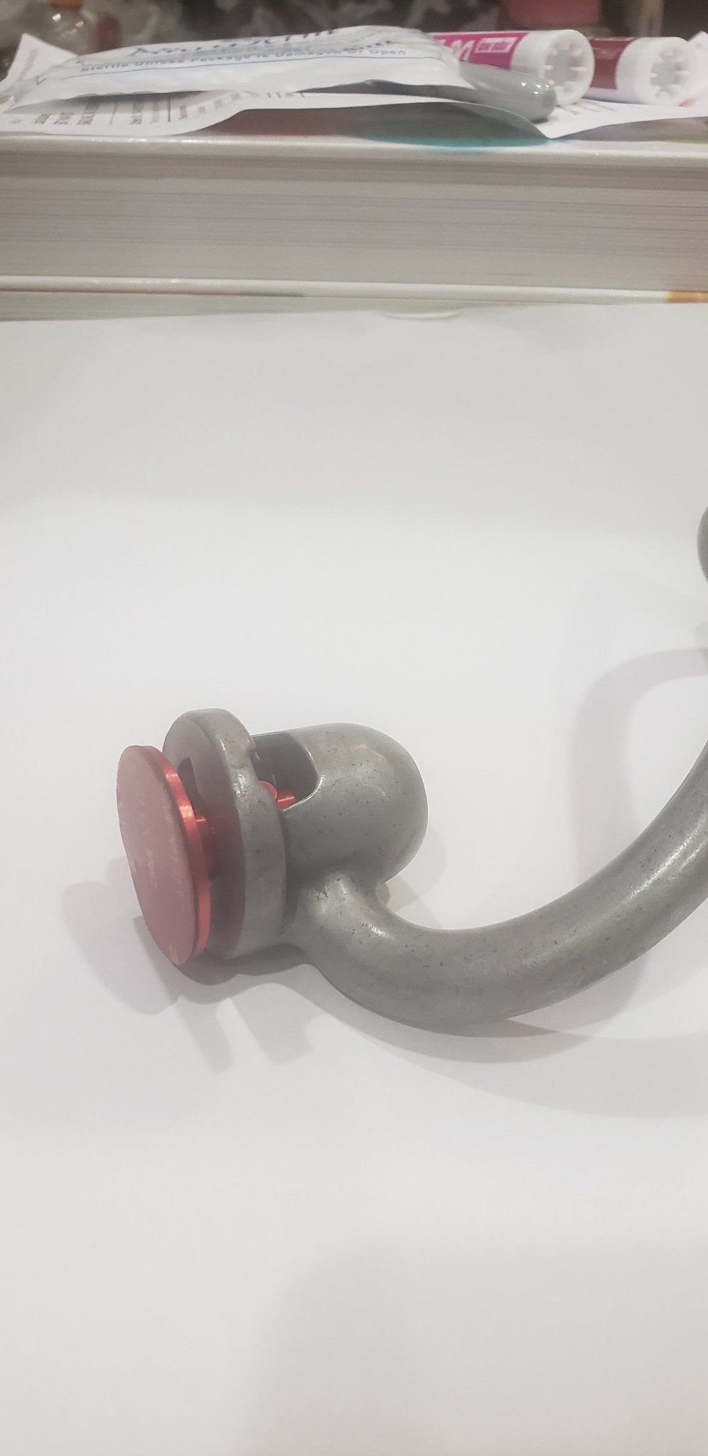 Close-up of a metallic object with a red accent on a white background