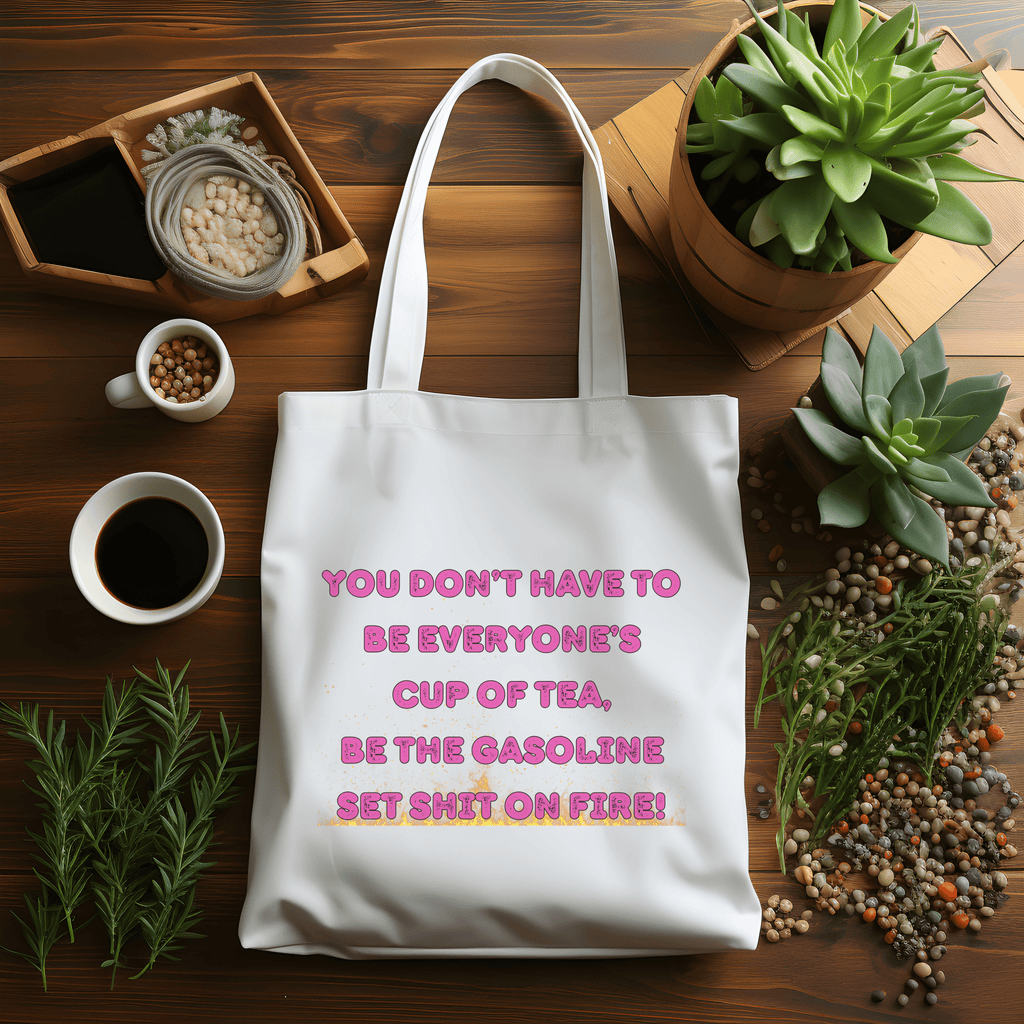 White tote bag with motivational quote on a wooden table with plants and coffee.