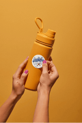 Hands hold a yellow water bottle with Olga Battle Crew UV DTF Decal featuring a bold blue cancer awareness ribbon.