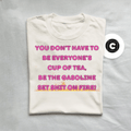 White t-shirt with pink and yellow text on a gray background