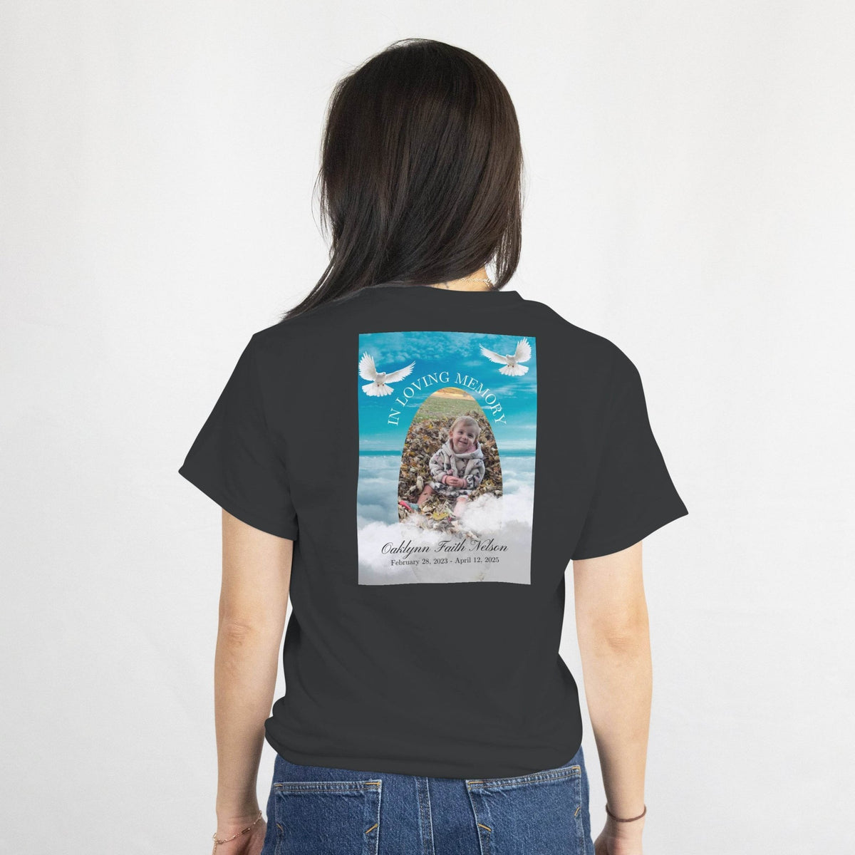 Woman wearing a Custom Memorial T-Shirt featuring a back design with photo, name, dates, arch frame, and doves.