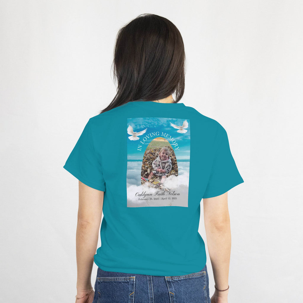 Teal tee back print: In Loving Memory memorial design with photo, name, and dates; two doves over an ocean sky.