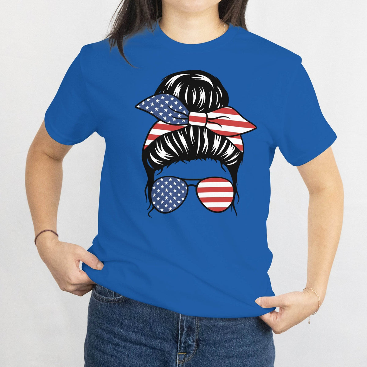 Gildan patriotic messy bun tee with star-spangled bandana and USA flag sunglasses graphic.