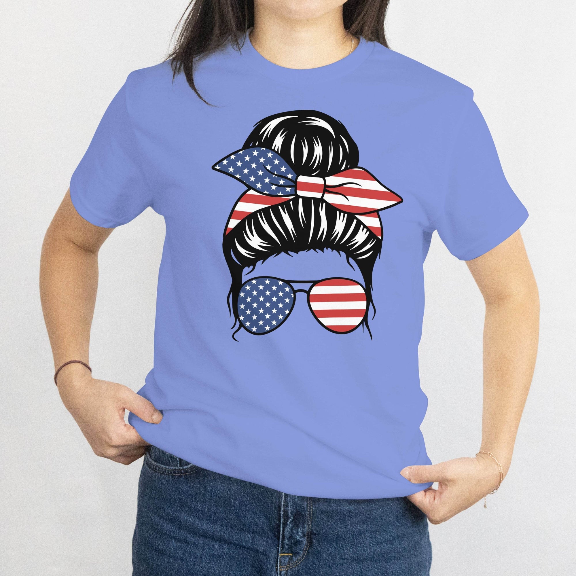 Gildan Patriotic Messy Bun Tee: blue tee with a messy bun graphic, star-spangled bandana, and American flag sunglasses.
