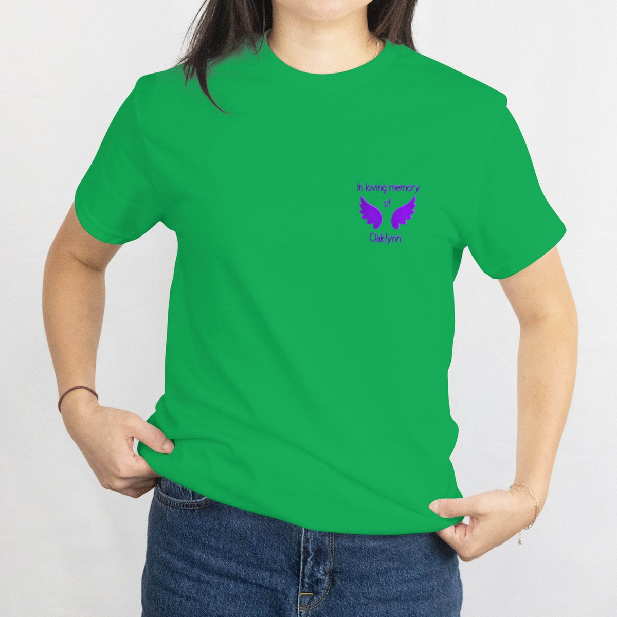 Bright green T-shirt with a small purple memorial design of wings and the name Oaklynn, In loving memory on the chest.