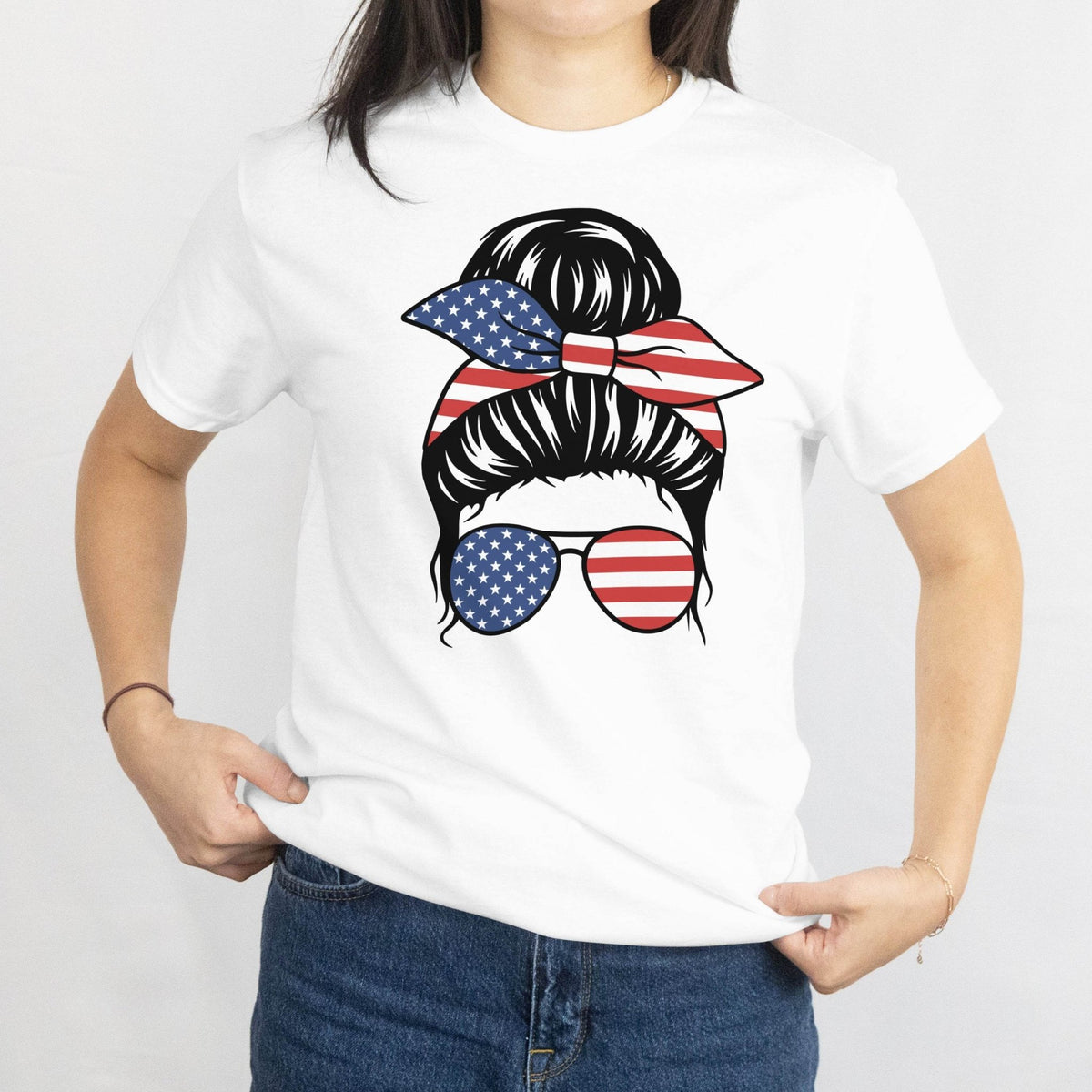 Gildan Patriotic Messy Bun T-Shirt: messy bun with star-spangled bandana and American flag sunglasses graphic.