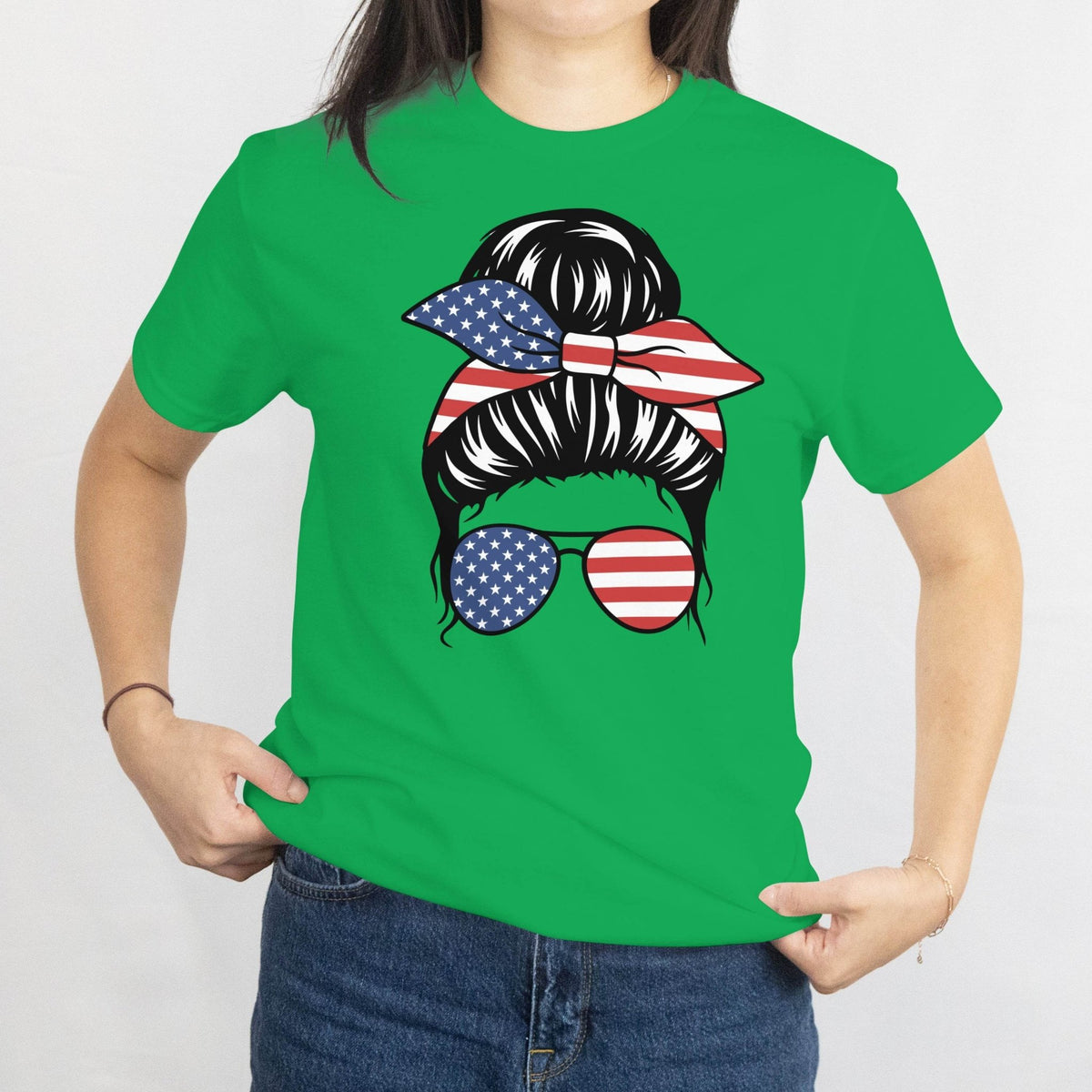 Green T-shirt with a graphic of a messy bun tied with a stars-and-stripes bandana and American flag sunglasses.
