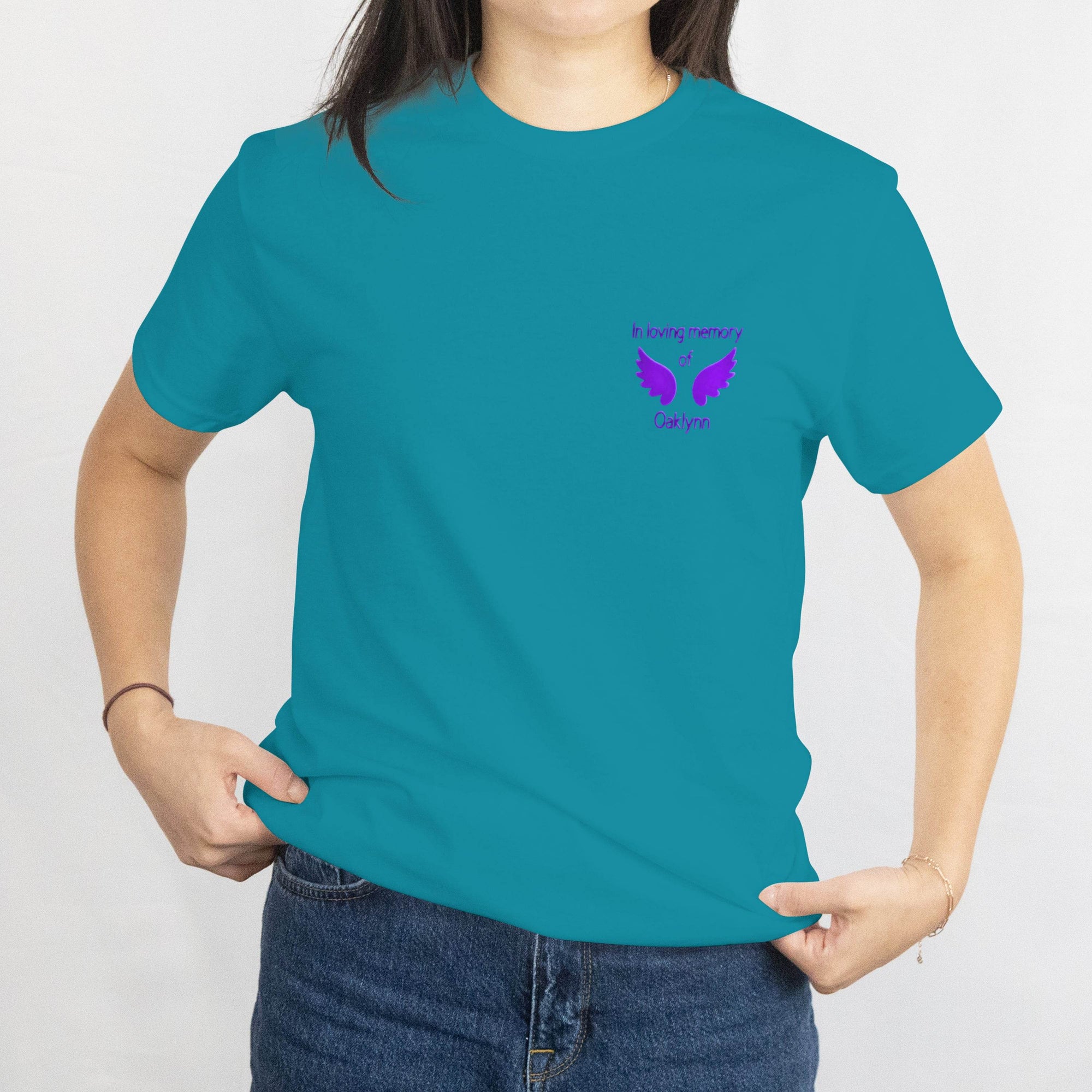 Teal memorial t-shirt with purple wings and In loving memory of Oaklynn on the chest.