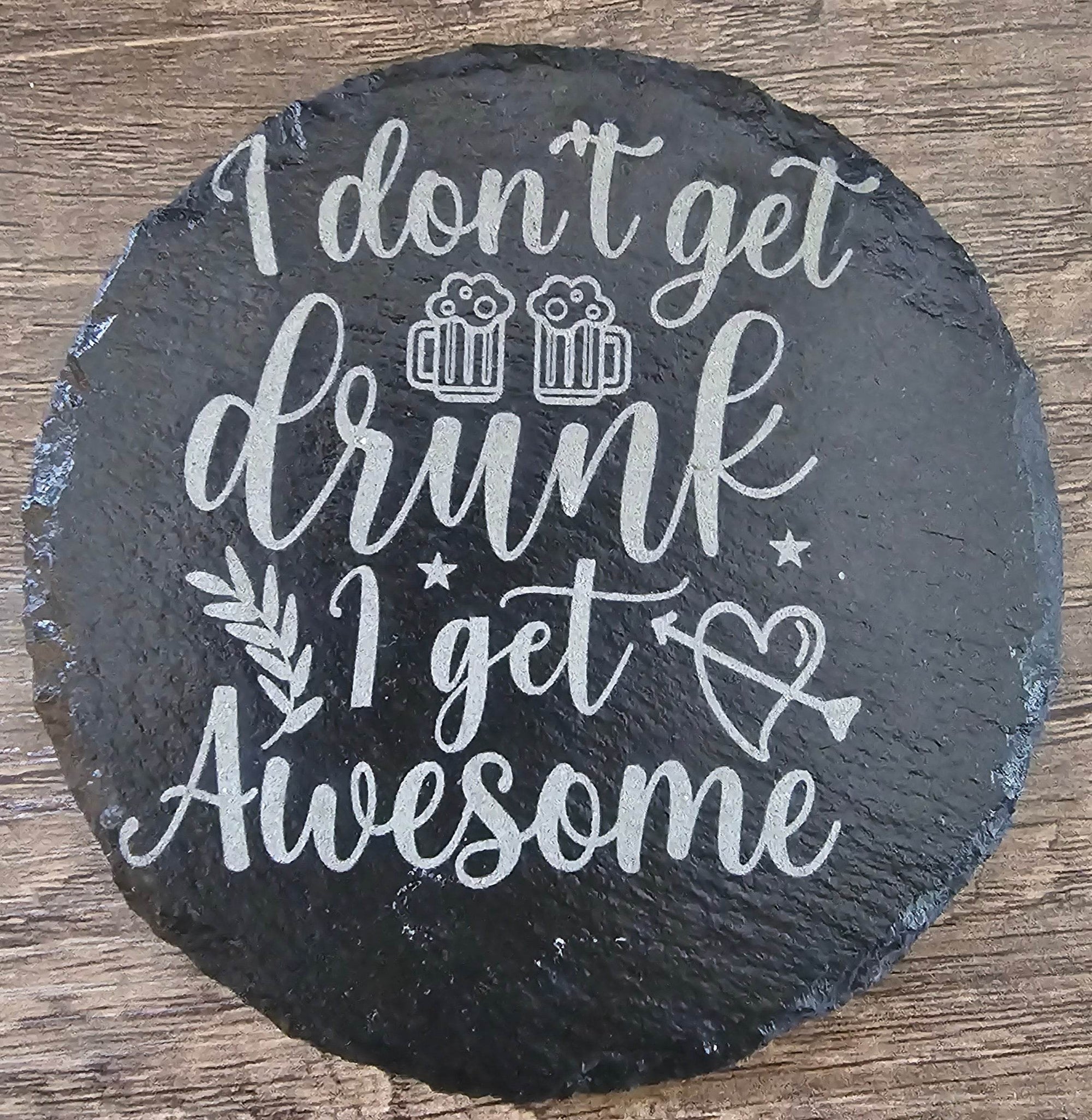 Round black slate coaster with white script I don't get drunk I get Awesome.