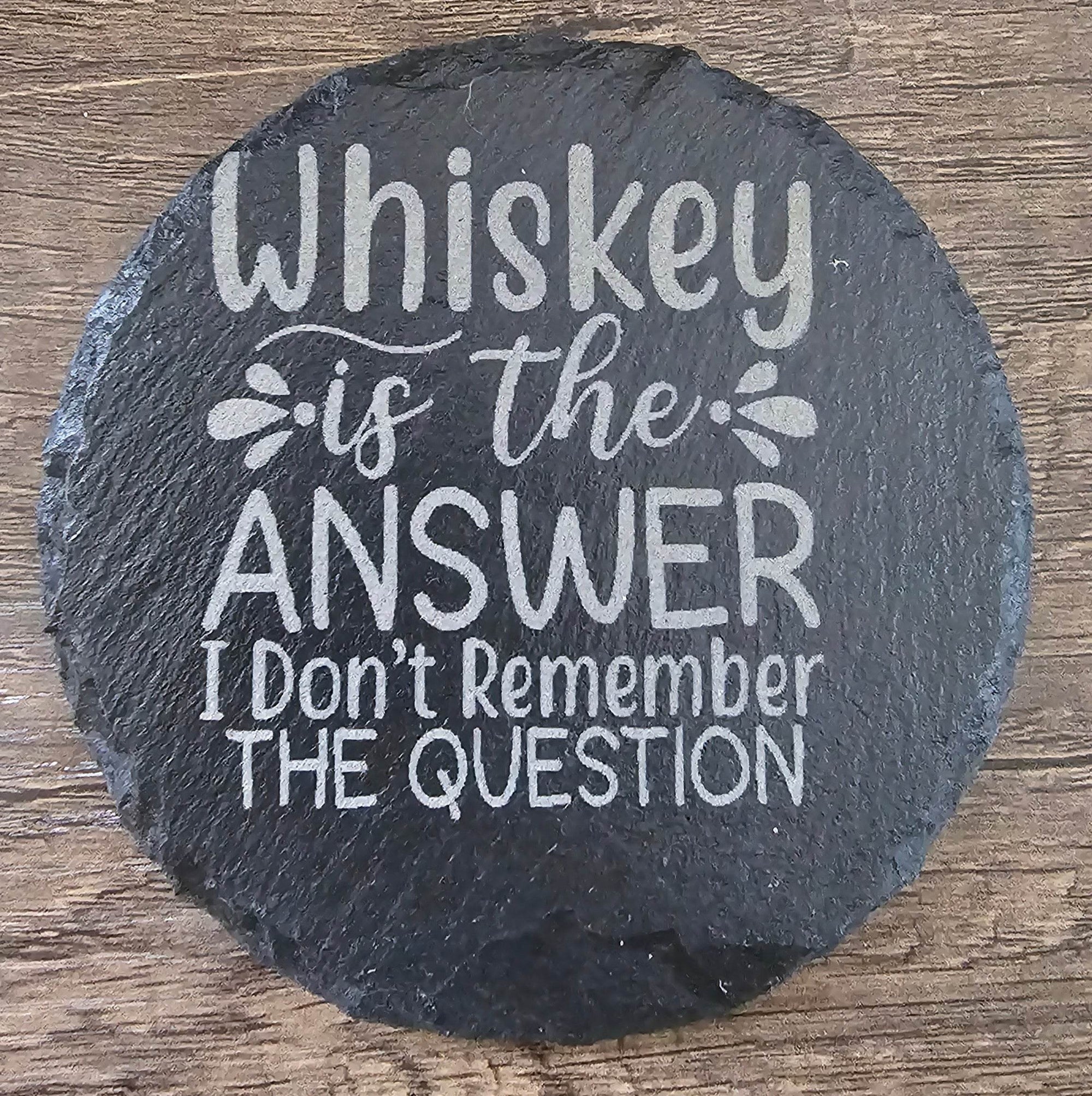 Round black slate coaster with whiskey quote: 'Whiskey is the ANSWER I Don't Remember THE QUESTION'