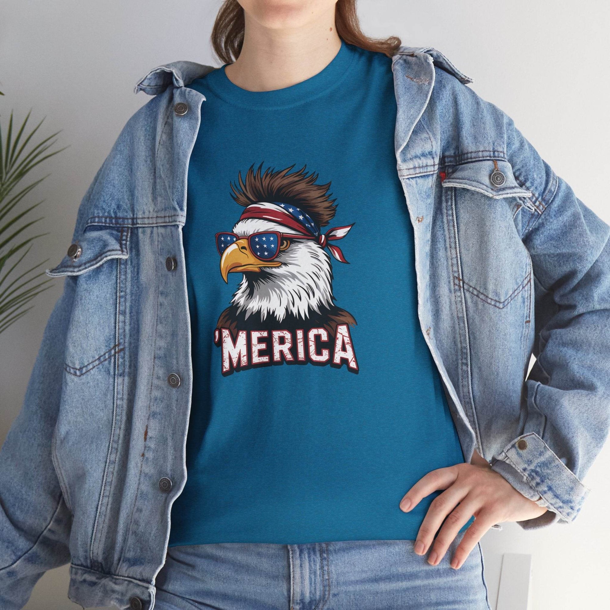 Person wearing a denim jacket showcases teal Merica Bald Eagle shirt with bandana, sunglasses, and MERICA text.