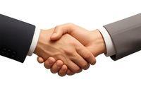 Two business hands shaking hands against a plain background