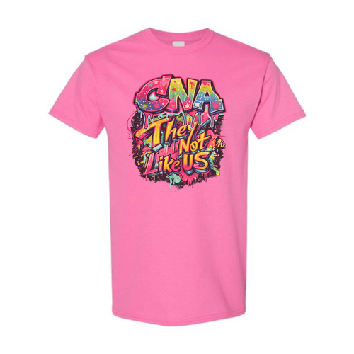 A bright pink short-sleeve t-shirt with a colorful graphic on the chest that reads 'CNA They Are Not Like Us' in a graffiti-style font, displayed on a clean white background.