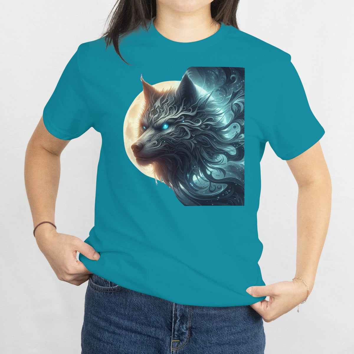 Person wearing a teal t-shirt with a wolf graphic design on a plain background