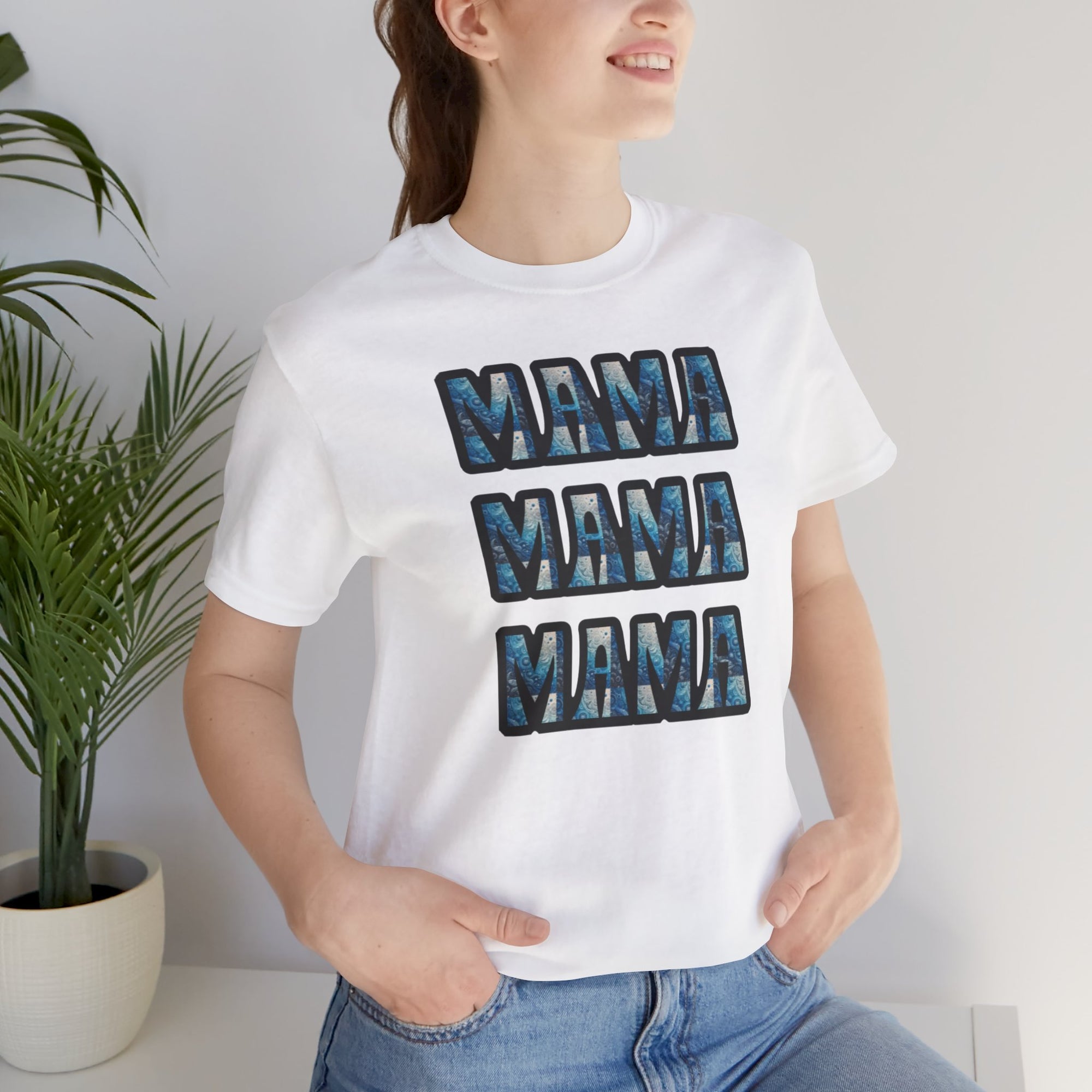 White T-shirt with three stacked 'MAMA' blocks in blue marble pattern worn by a smiling woman.