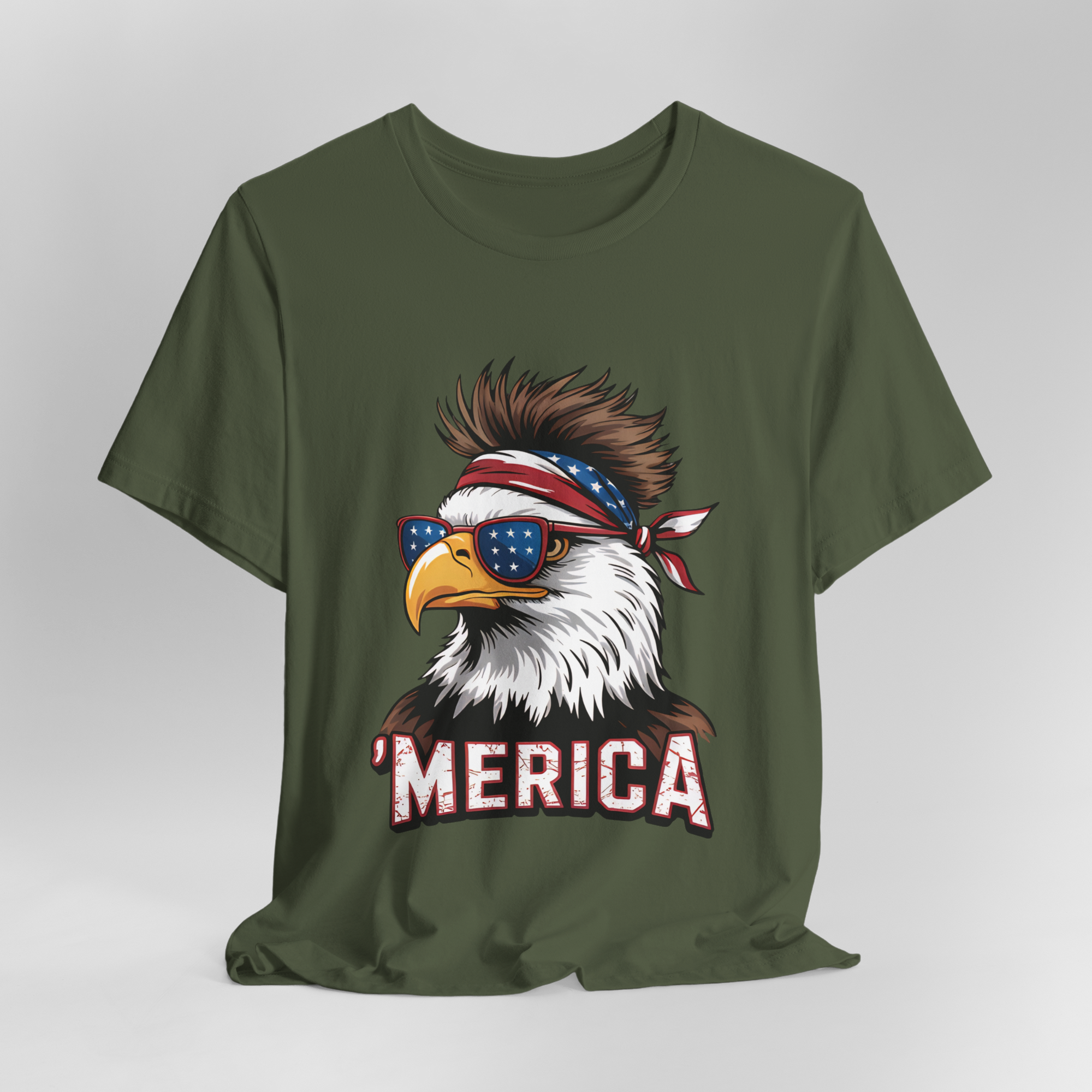 Olive green Bella Canvas unisex tee featuring an eagle with star-spangled sunglasses, bandana, and MERICA lettering.