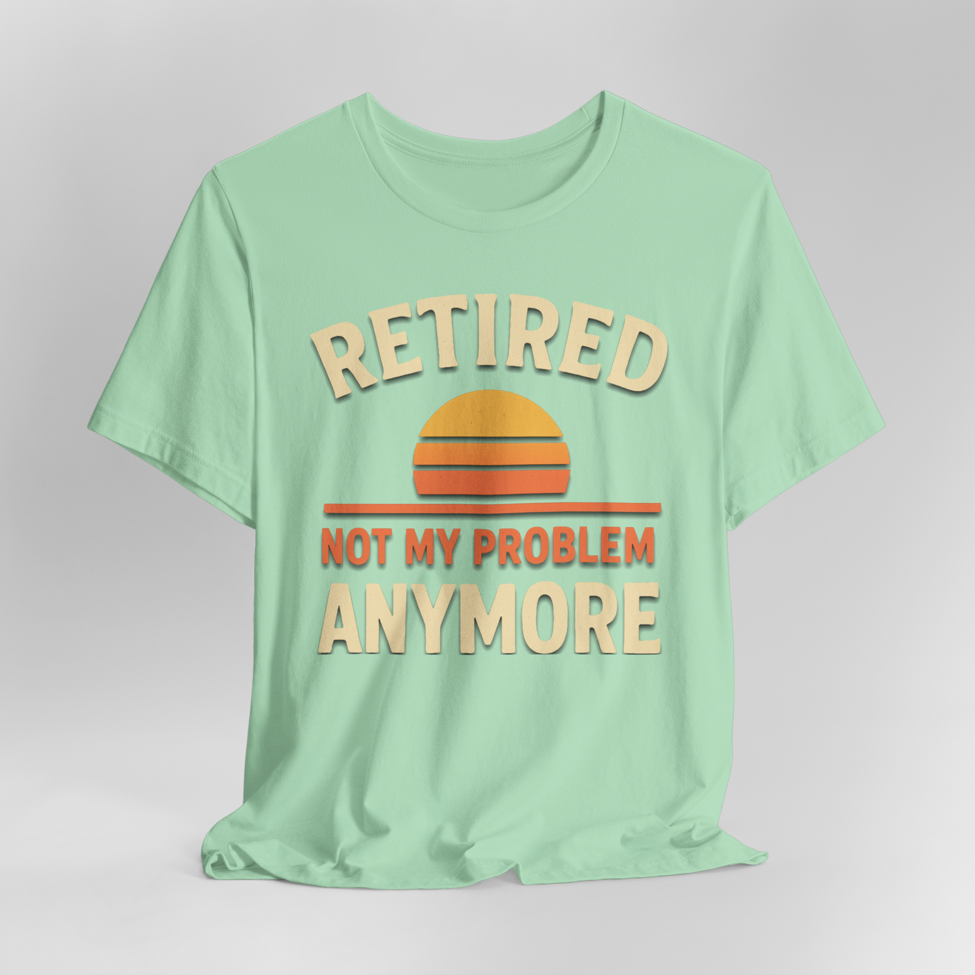 Mint green T-shirt featuring retro sunset graphic and bold cream text: Retired not my problem anymore.