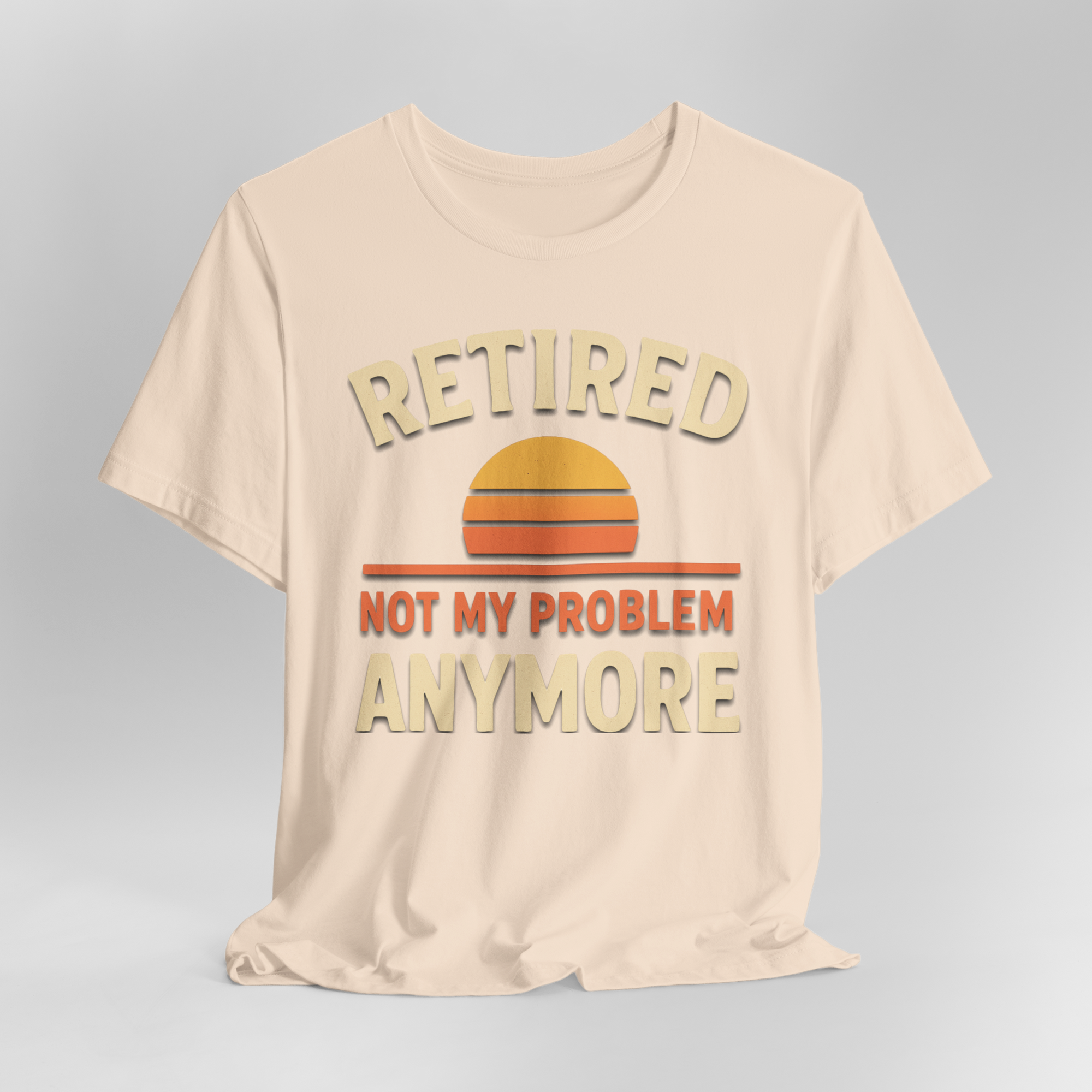 Beige tee with retro sunset graphic and bold stacked text RETIRED NOT MY PROBLEM ANYMORE.