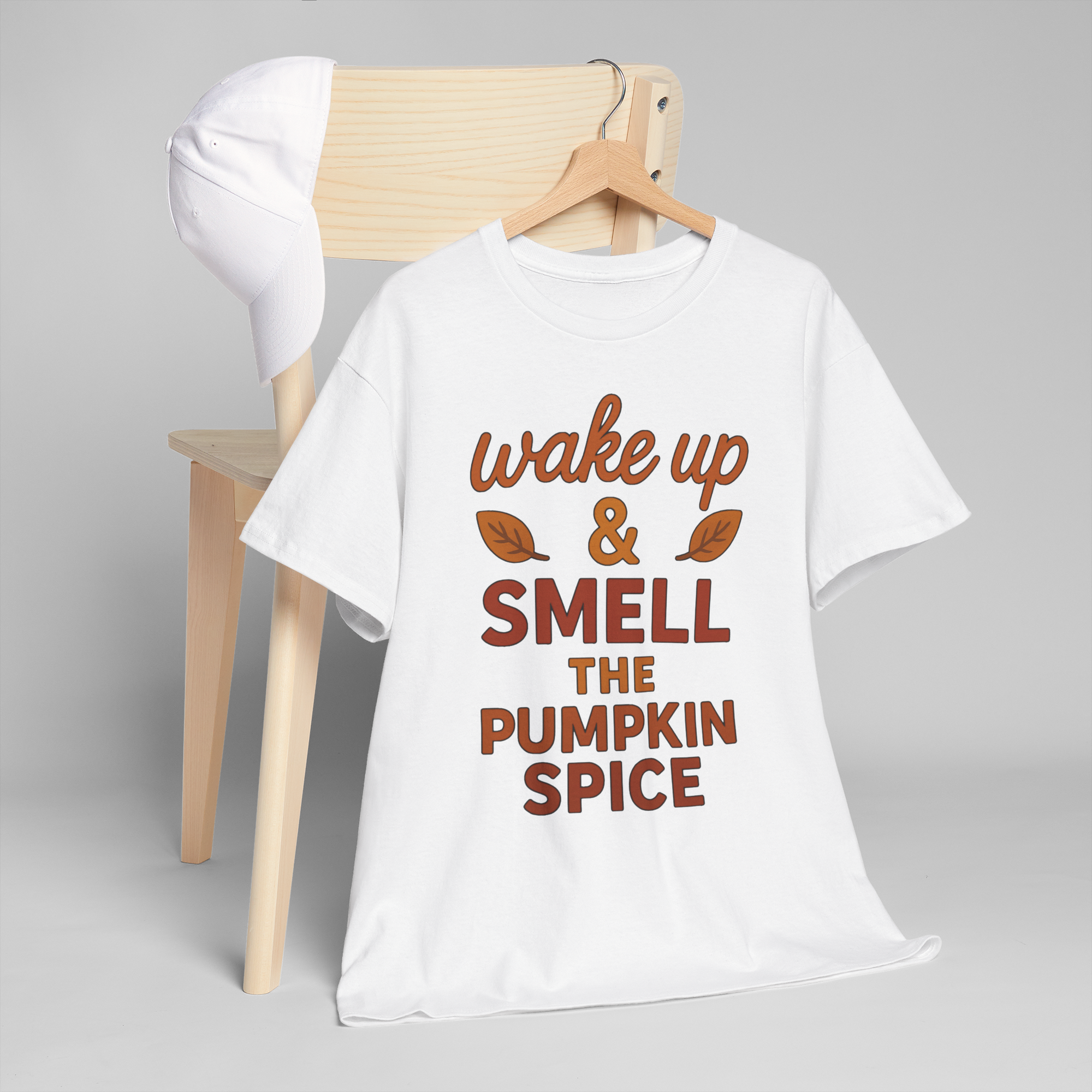 Gildan 5000 white tee on a hanger with orange pumpkin spice print that reads wake up & smell the pumpkin spice.