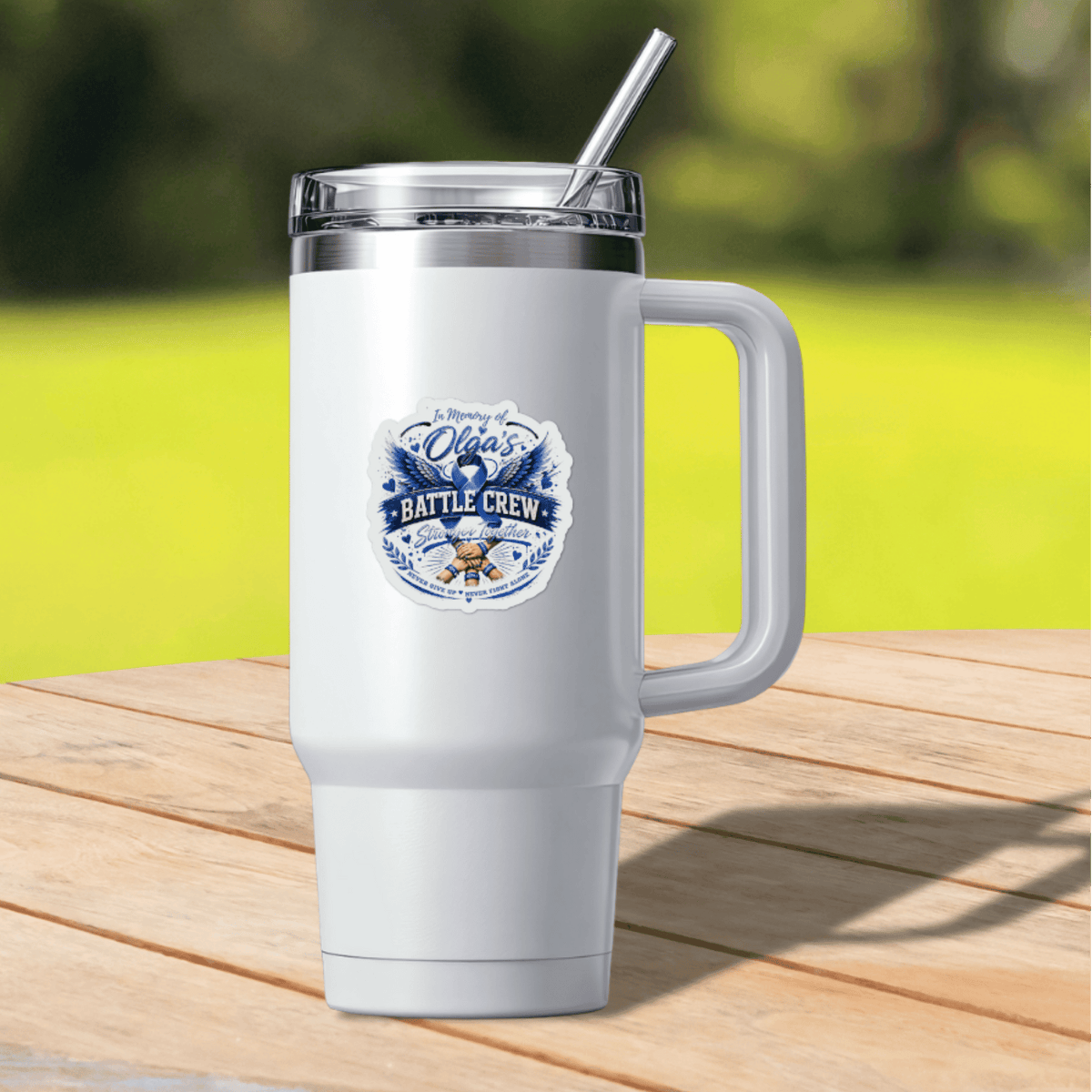 White insulated tumbler with a blue memorial sticker reading In Memory Of Olga's Battle Crew.