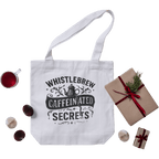 White tote bag with 'Whistlebrew Caffeinated Secrets' text, surrounded by a gift box and coffee cup on a green background
