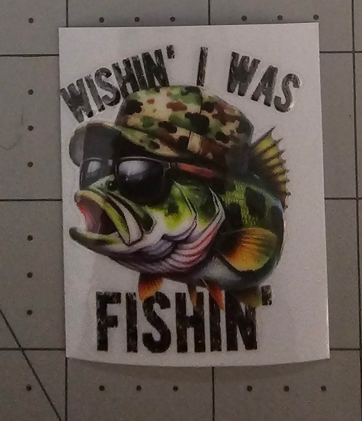 Fish wearing sunglasses and a hat with text 'Wishin' I Was Fishin'' on a white background