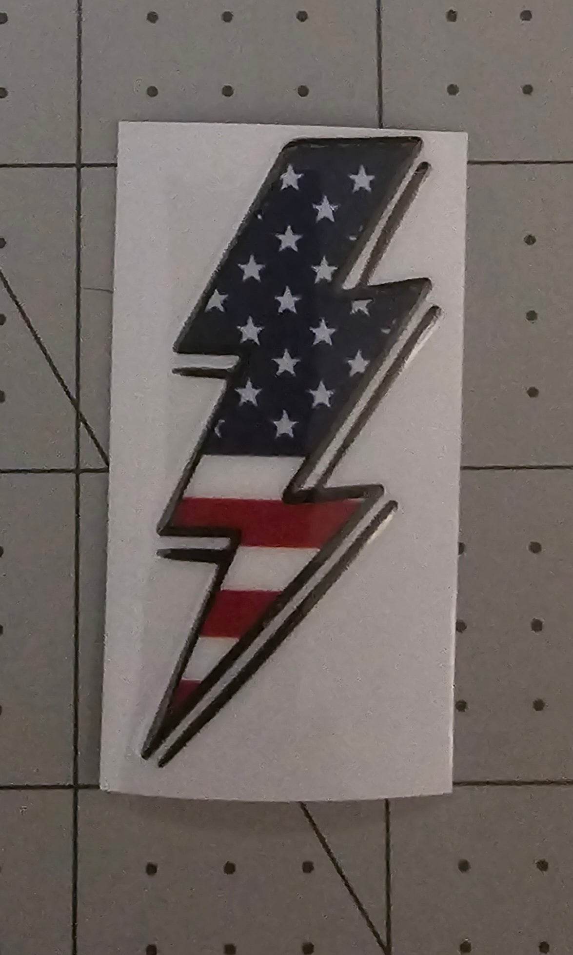 American flag lightning bolt design on a white card with a grid background