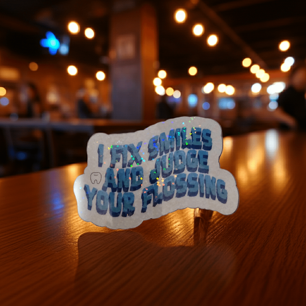 Sticker with humorous text on a wooden table in a dimly lit room.