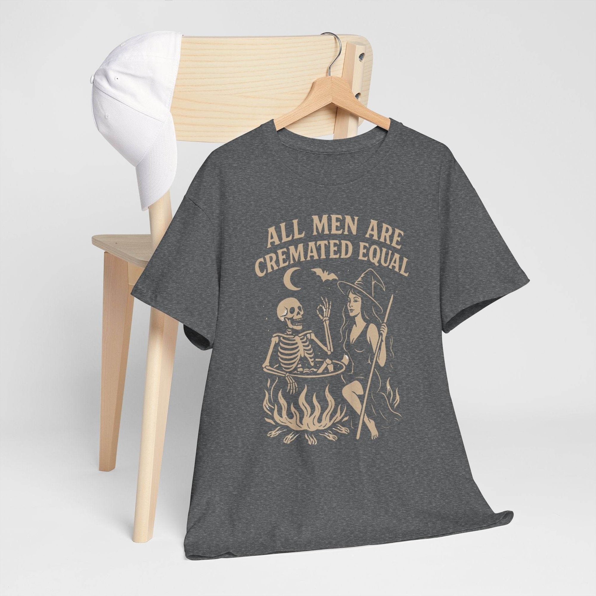 All Men Are Cremated Equal witch cauldron tee on charcoal-gray shirt with vintage gothic design.