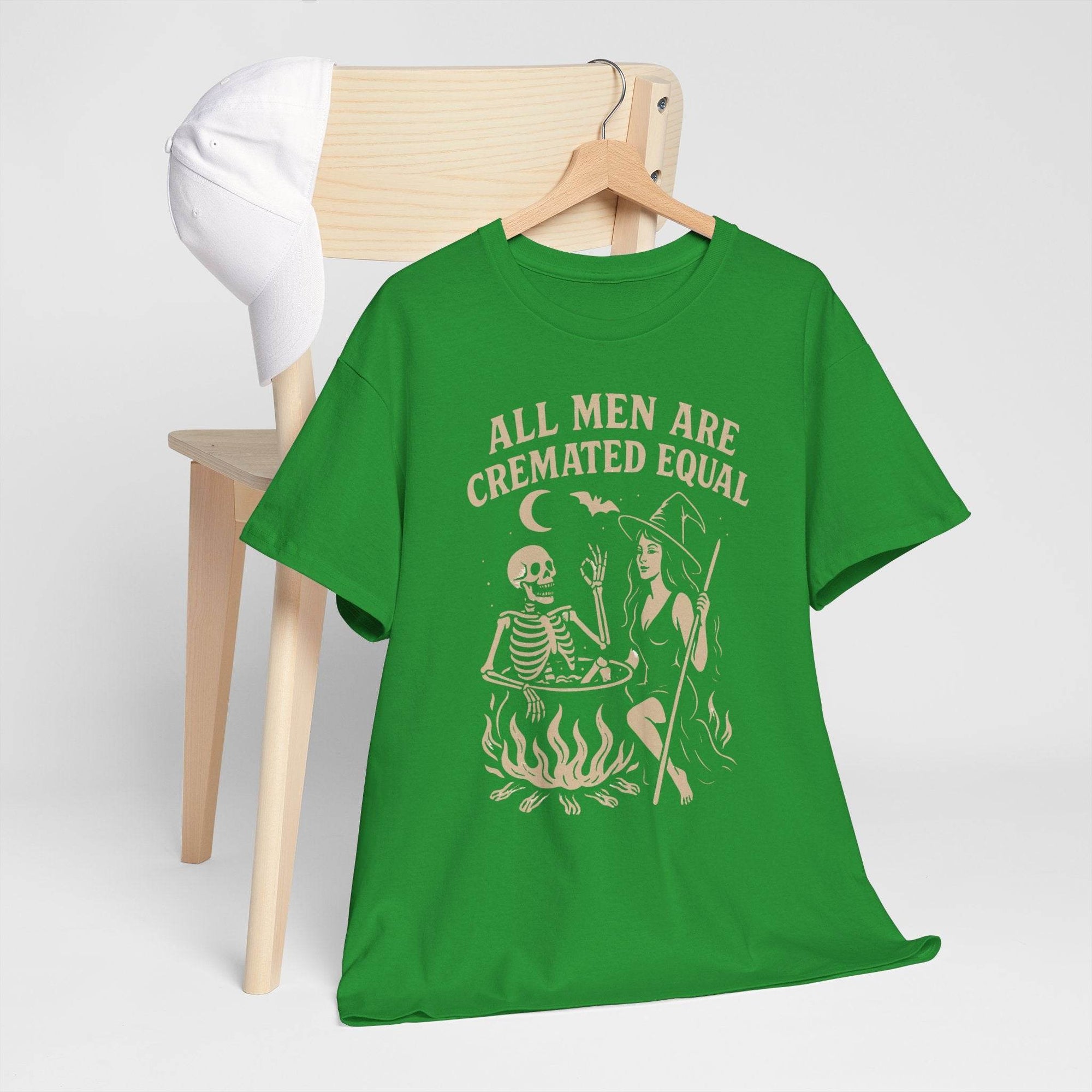 Green T-shirt featuring a witch at a cauldron with a skeleton and the text All Men Are Cremated Equal.