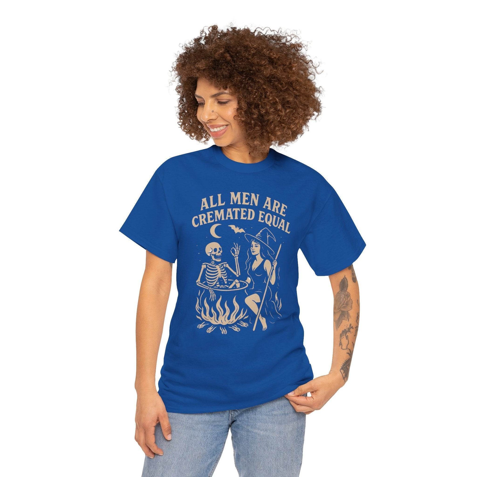 Blue tee on a model featuring vintage cauldron scene with witch and skeleton, bold All Men Are Cremated Equal text.