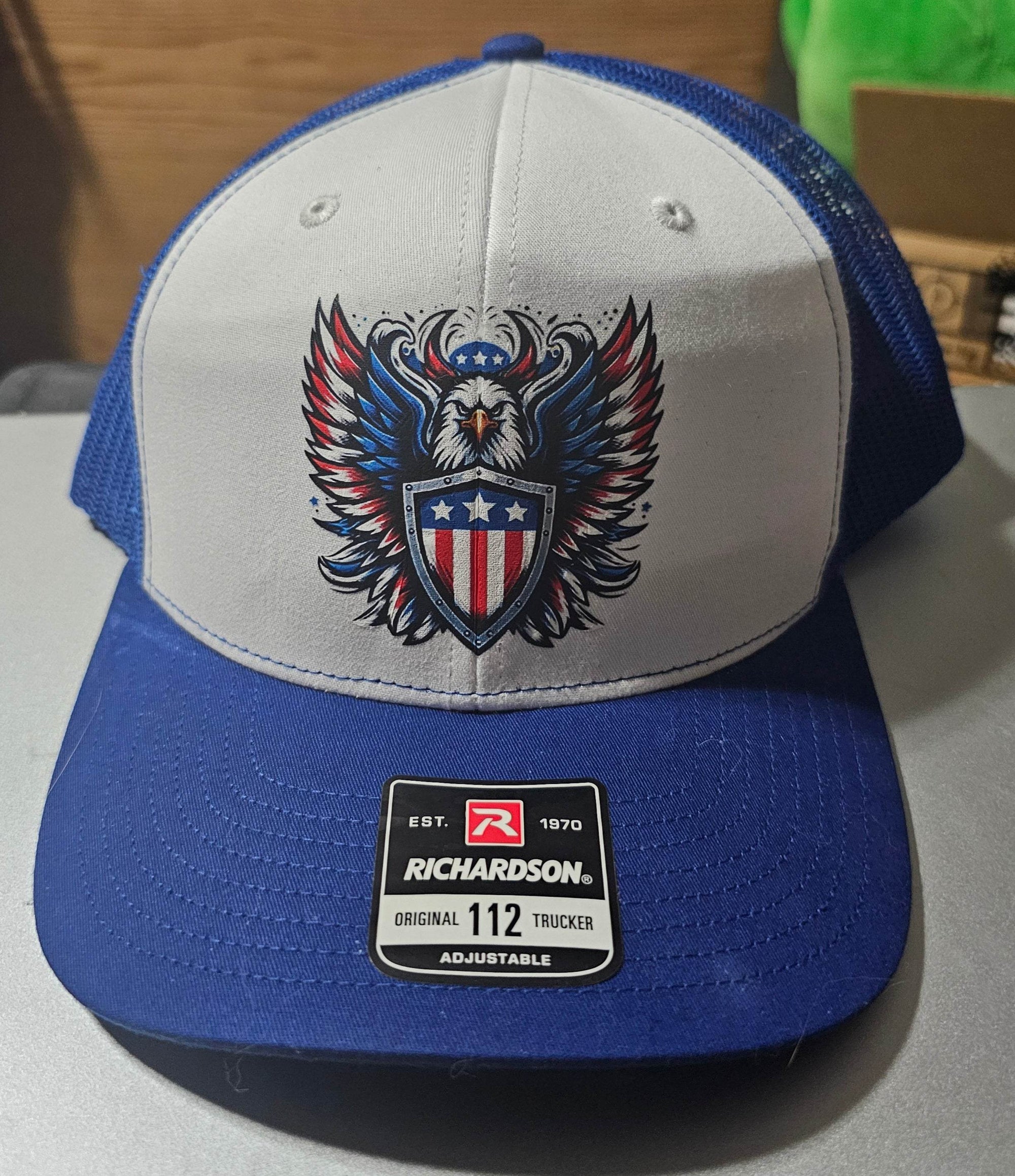 Custom Richardson 112 trucker hat with eagle shield design on white front panel and blue mesh back.