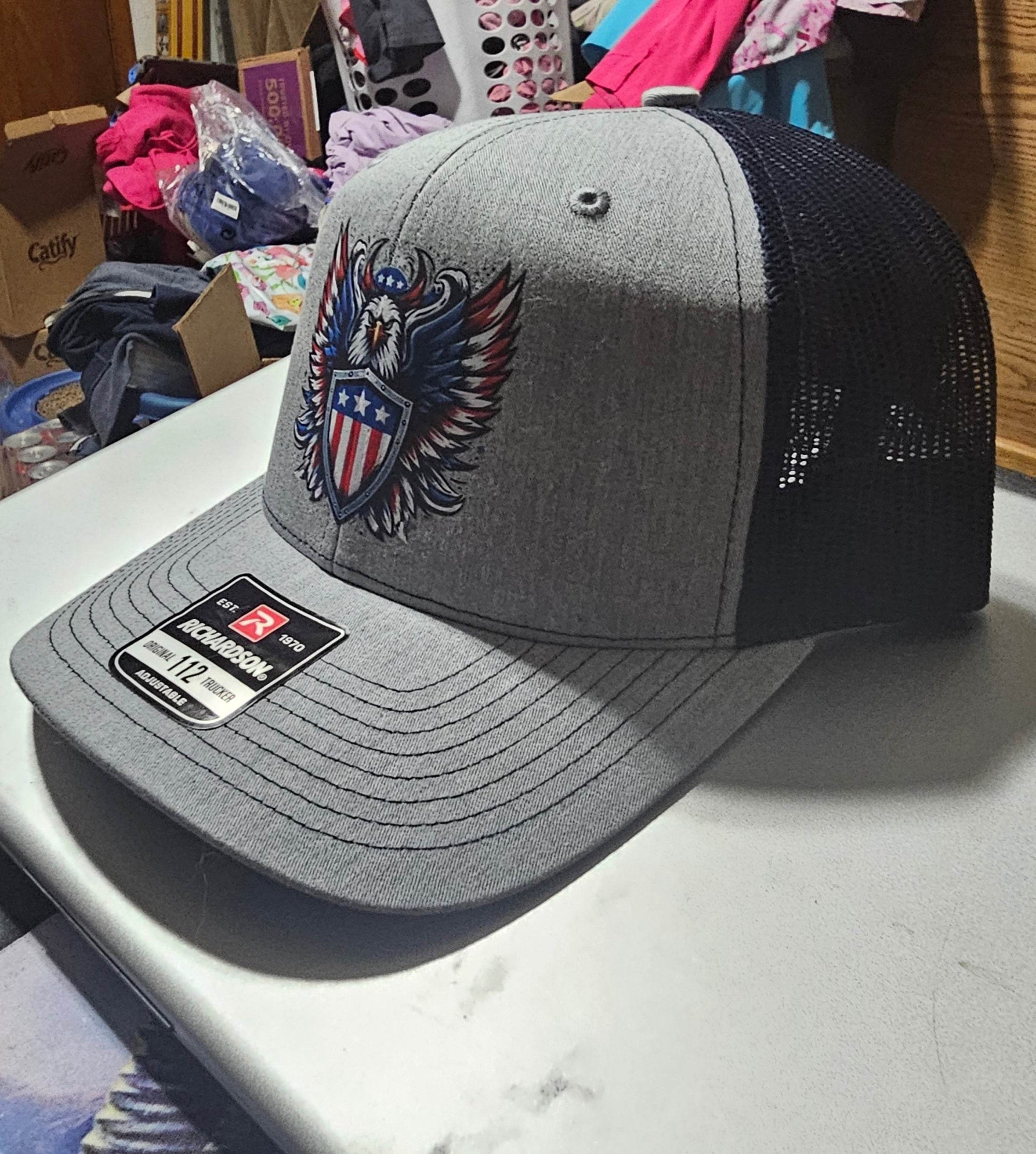 Custom Richardson 112 trucker hat with bold eagle holding a shield on a gray front panel.
